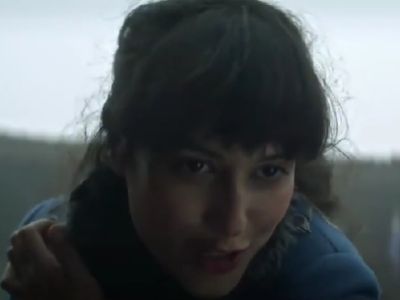 Sujaya Dasgupta is looking down and talking to someone.